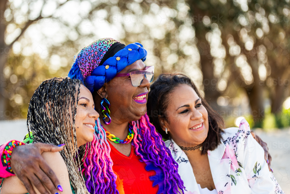 Torres Strait Islander woman with her daughters sitting together on the beach - Australian Stock Image