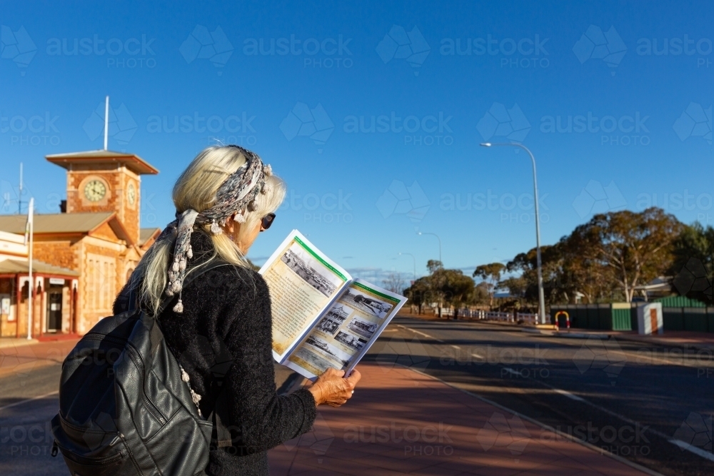 tourist reading visitor guide in historic goldfields town - Australian Stock Image