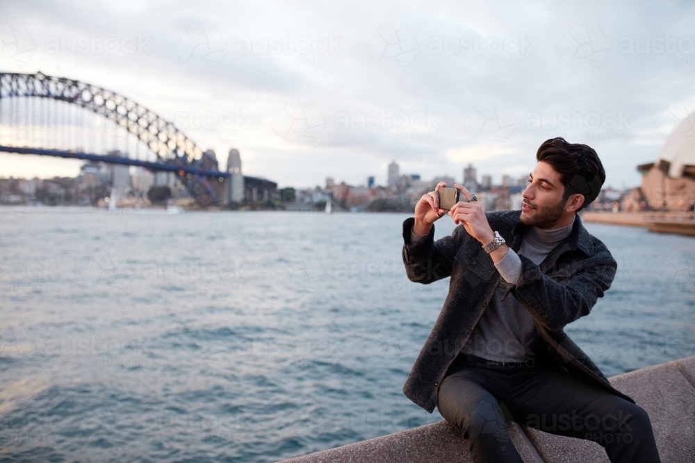 Tourist taking a photo with the Sydney Harbour Bridge in background - Australian Stock Image