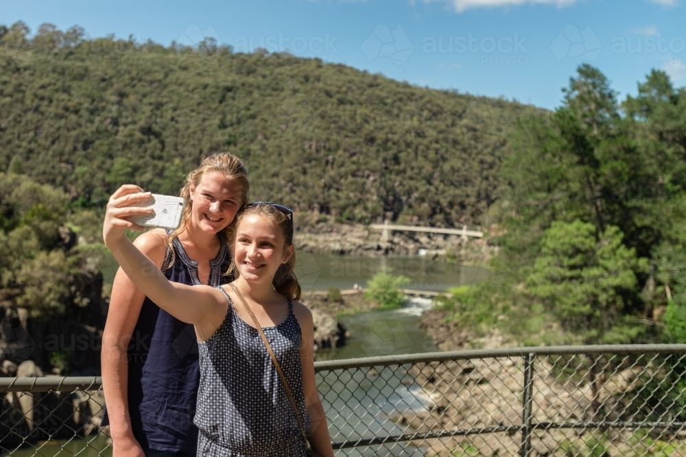 tourists girls taking photos on their phone, Tasmania - Australian Stock Image