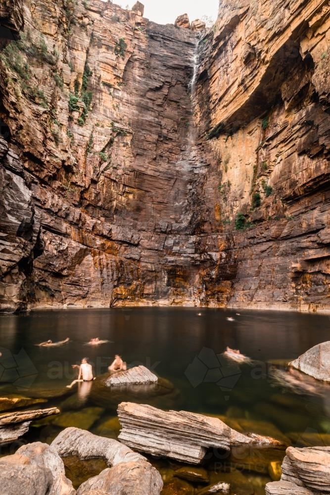 Tourists swimming in the safe waterhole at Jim Jim Falls, Kakadu - Australian Stock Image