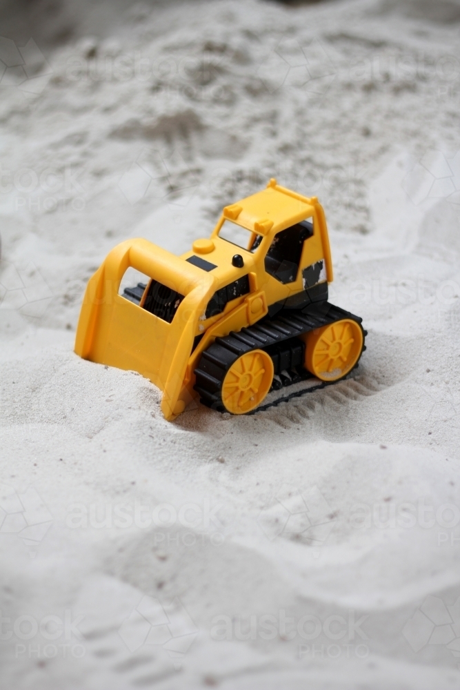 Toy bulldozer in sandpit - Australian Stock Image