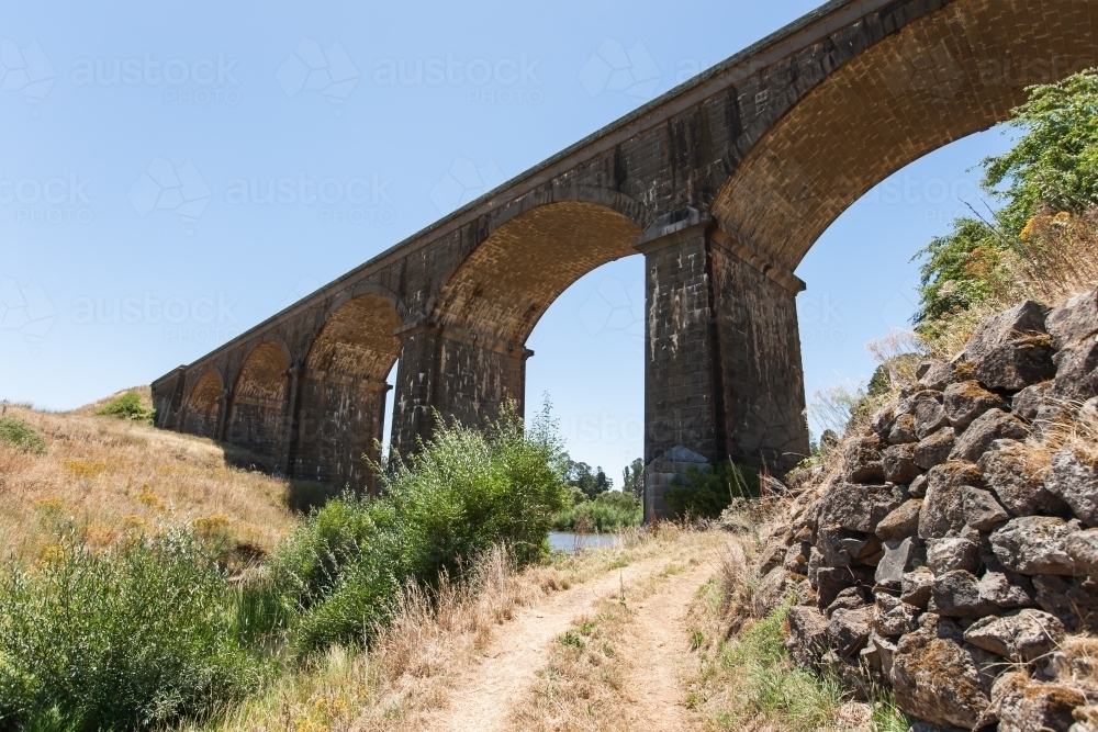 track leading under a arch railway bridge - Australian Stock Image