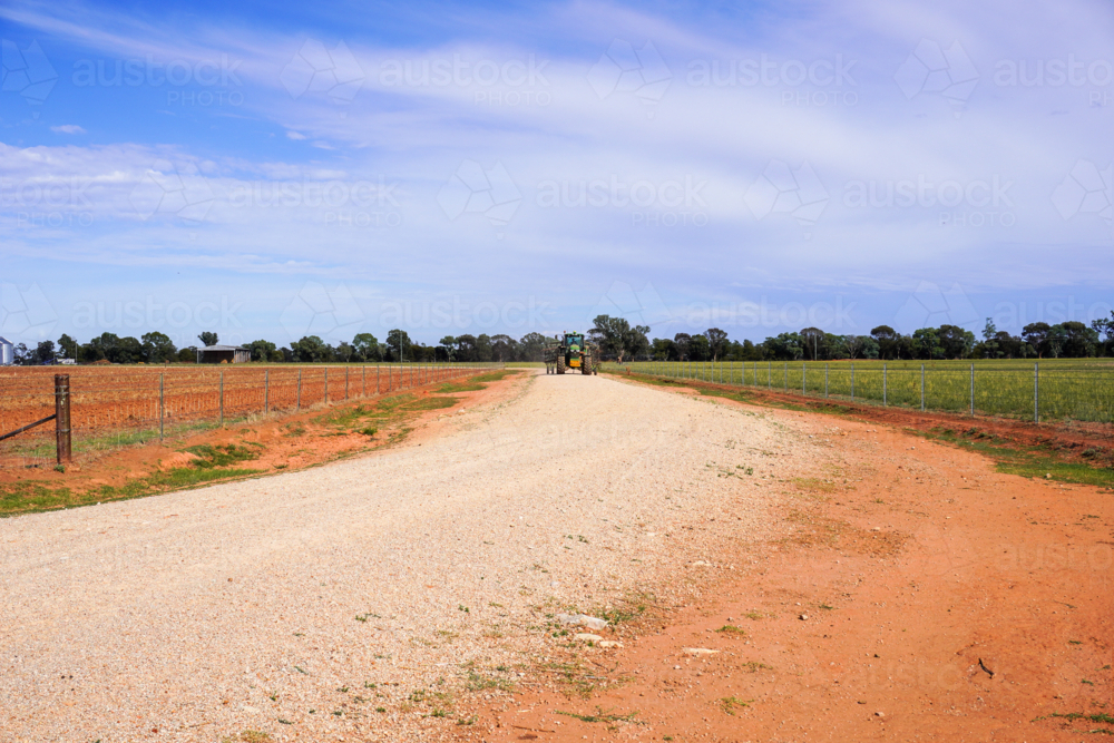 tractor driving down a lane way on a farm - Australian Stock Image