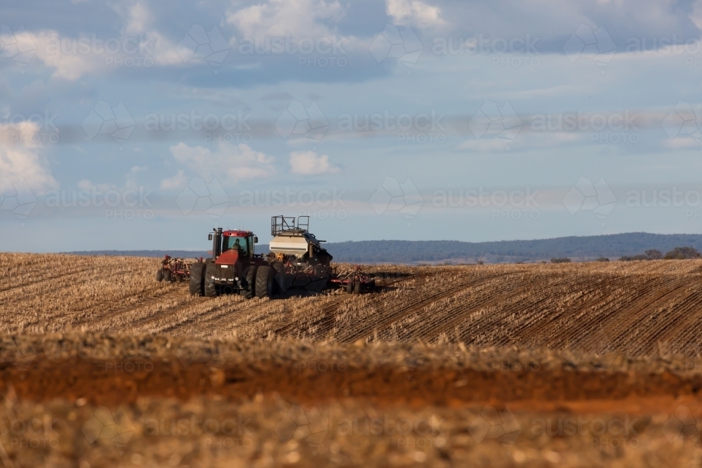 tractor ploughing soil in a dry paddock - Australian Stock Image