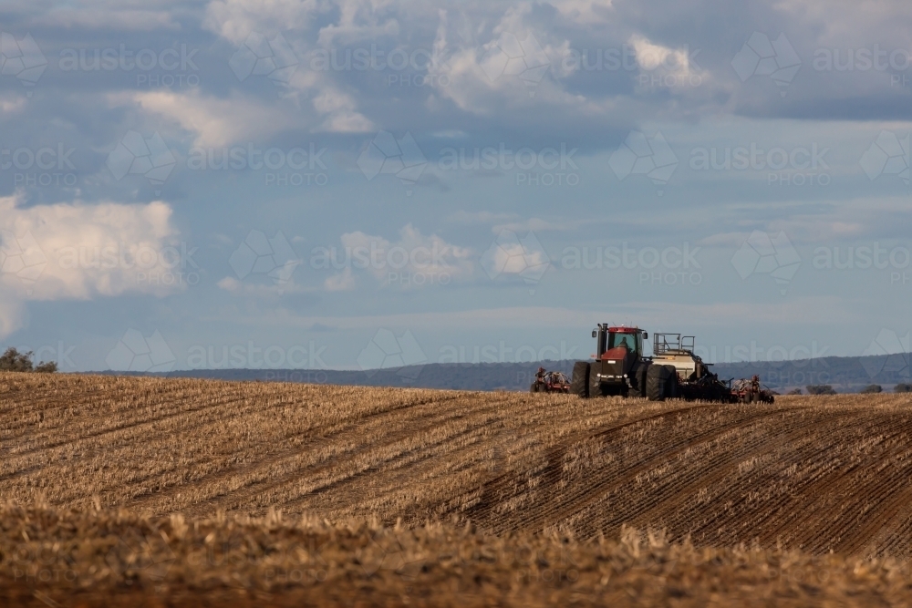 tractor ploughing soil in farm paddock - Australian Stock Image