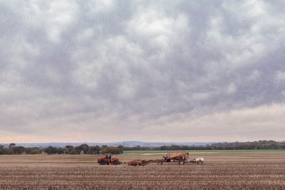 Tractor seeding paddock on an overcast day - Australian Stock Image