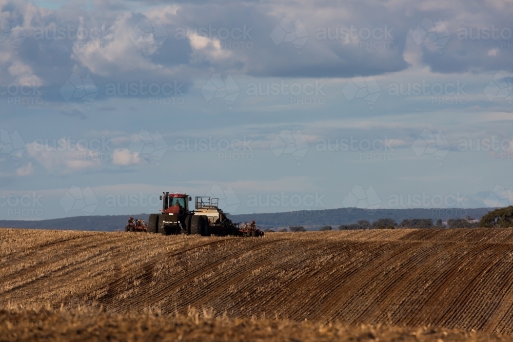 Tractors ploughing dirt in a dry paddock - Australian Stock Image