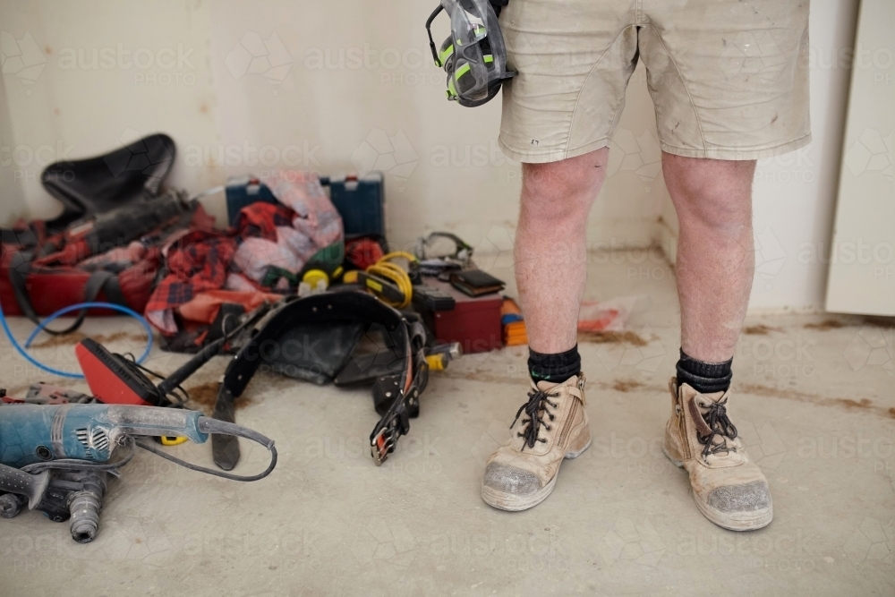 Tradesman standing in a room in a construction zone - Australian Stock Image