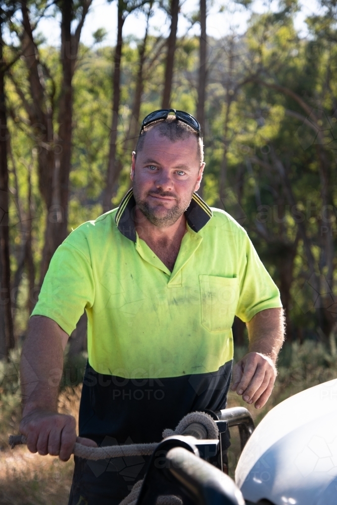 Image of Tradie Arborist tying rope to ute ready to pull tree down ...