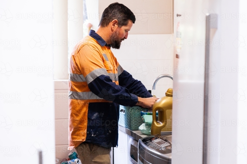 Tradie dad in laundry looking for socks - Australian Stock Image
