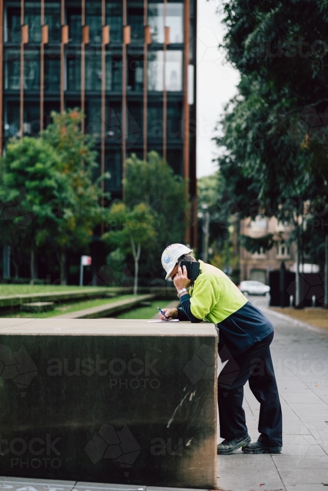 Tradie in the city making a phone call - Australian Stock Image