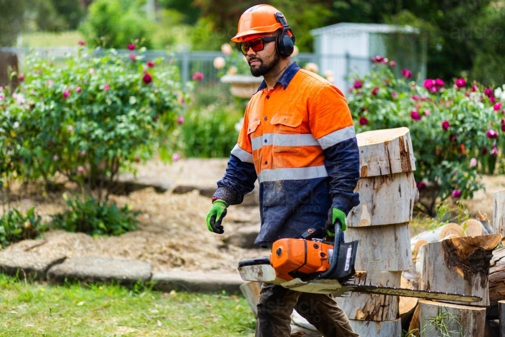 Tradie workman with chainsaw in garden - Australian Stock Image