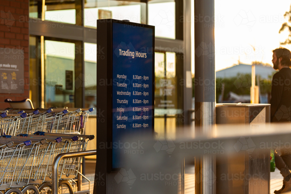 Trading hours sign outside grocery shopping centre - Australian Stock Image
