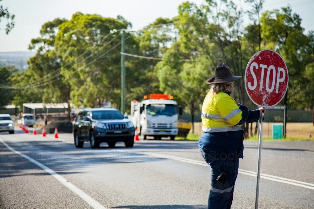 Traffic controller holding a stop sign - Australian Stock Image