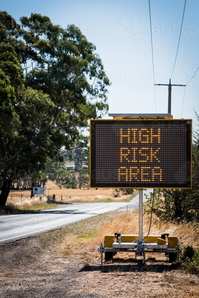 Image of Traffic safety sign with High Risk Area illuminated - Austockphoto