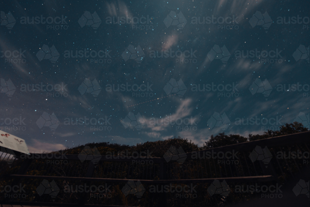 Trail of satellite passing through stars in the night sky - Australian Stock Image