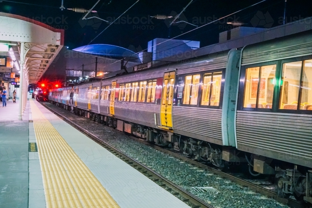 Train pulling out of station at night - Australian Stock Image
