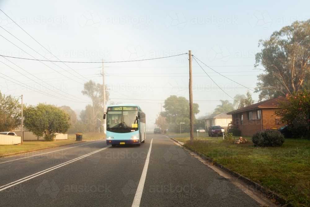Image of train replacement bus driving through misty street of town in ...