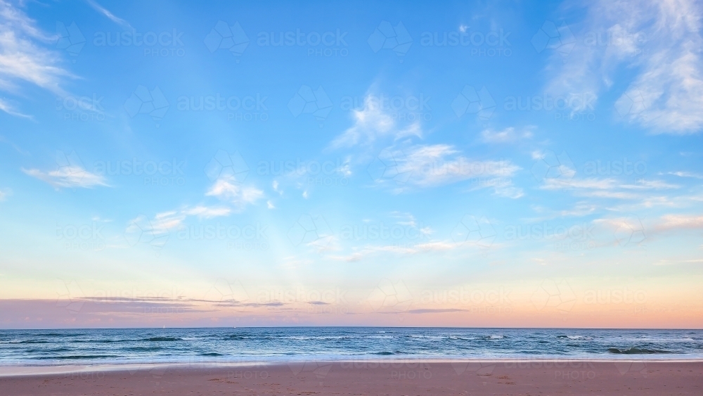Tranquil beach scene with rays of sunlight - Australian Stock Image