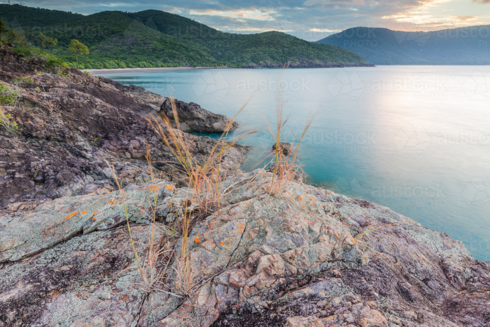 Tranquil tropical coastline mountains seascape at sunset in Queensland - Australian Stock Image