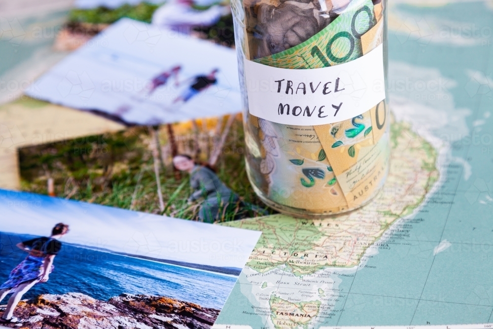 Travel in Australia to coastal destination concept - money in jar on map with holiday photos - Australian Stock Image