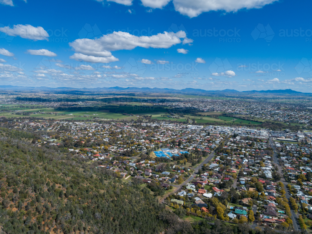 Tree covered hill from aerial view leading down to Tamworth a regional city in NSW - Australian Stock Image