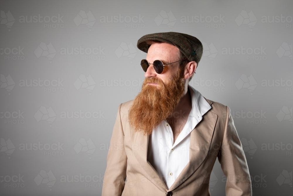 Trendy man with ginger beard and flat cap - Australian Stock Image
