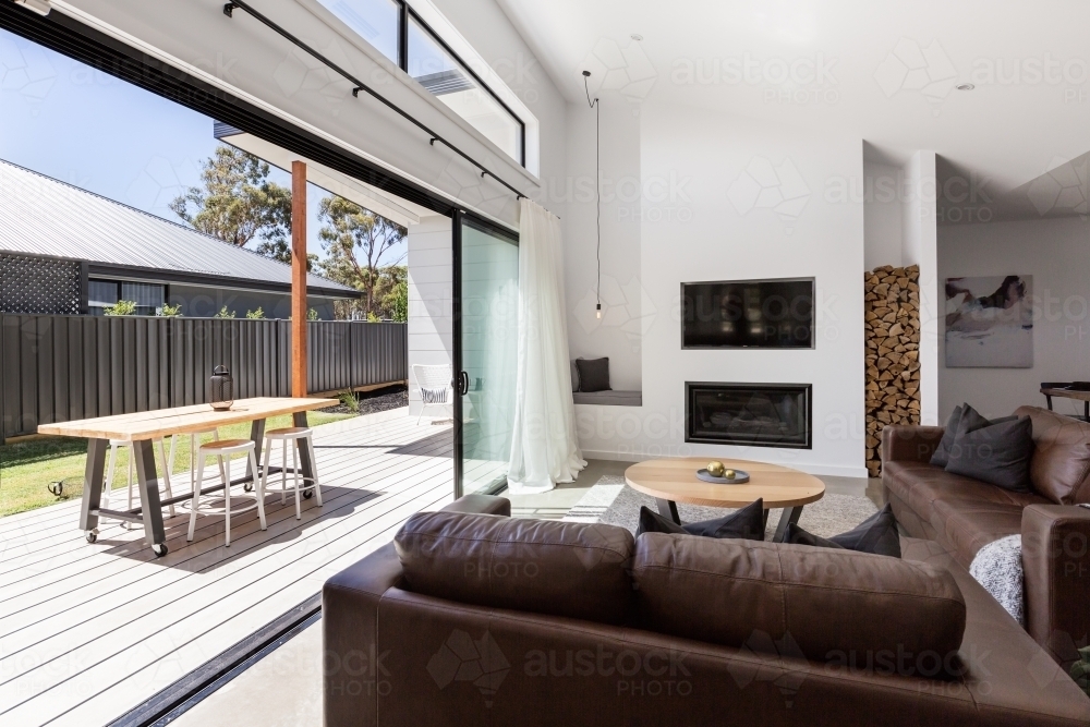 Triple sliding back glass doors from living room to outdoor deck - Australian Stock Image