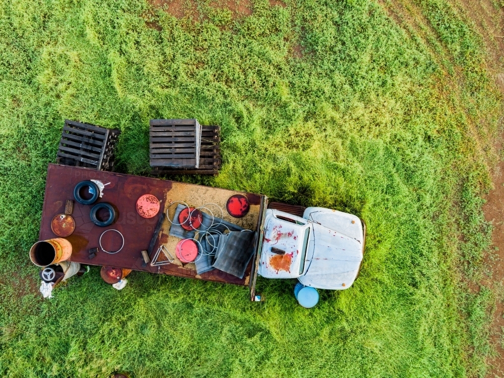 Truck and old farm junk seen from overhead on green farm - Australian Stock Image