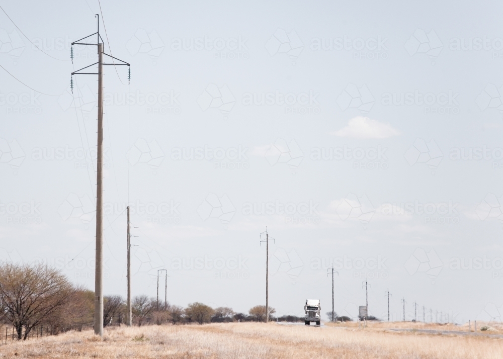 Truck and power poles on remote highway - Australian Stock Image