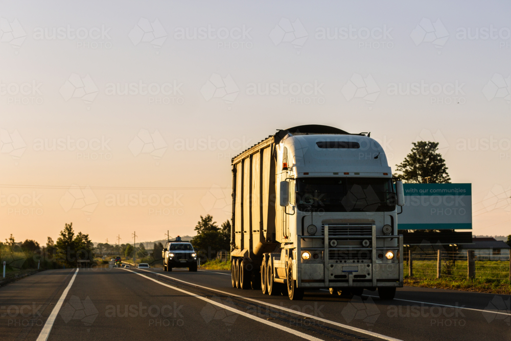 Truck on highway transporting good in dusk light - Australian Stock Image