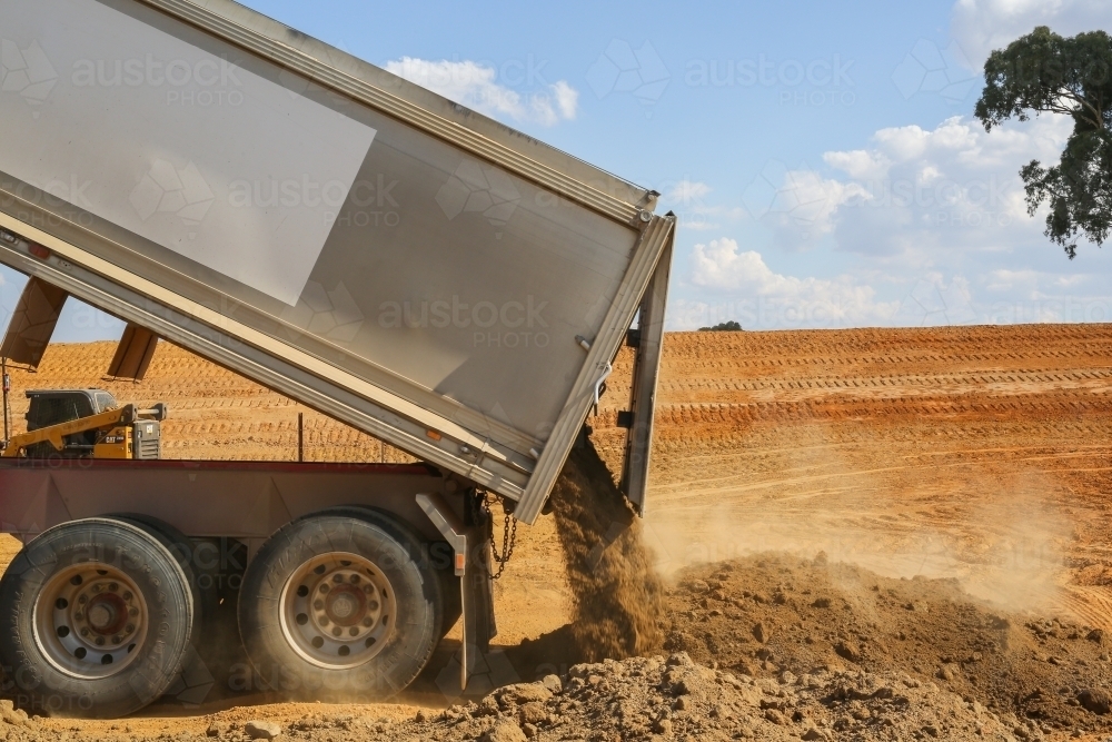 truck tipping soil on a construction site - Australian Stock Image