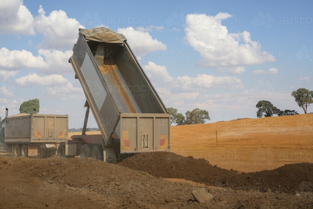 truck tipping soil on a construction site - Australian Stock Image