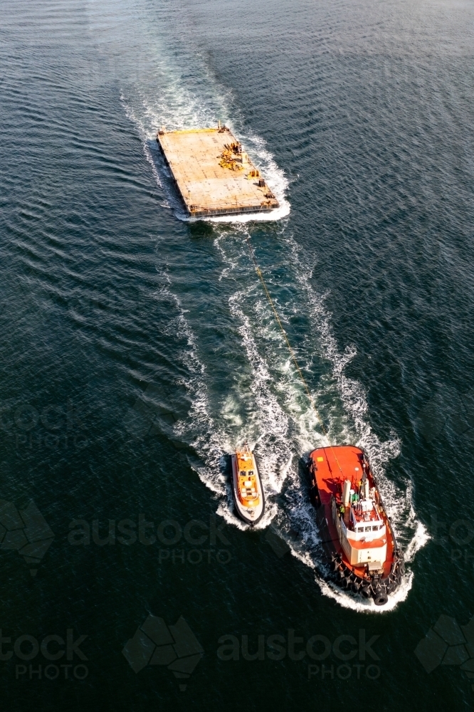 Tug boat towing barge with pilot boat alongside - Australian Stock Image