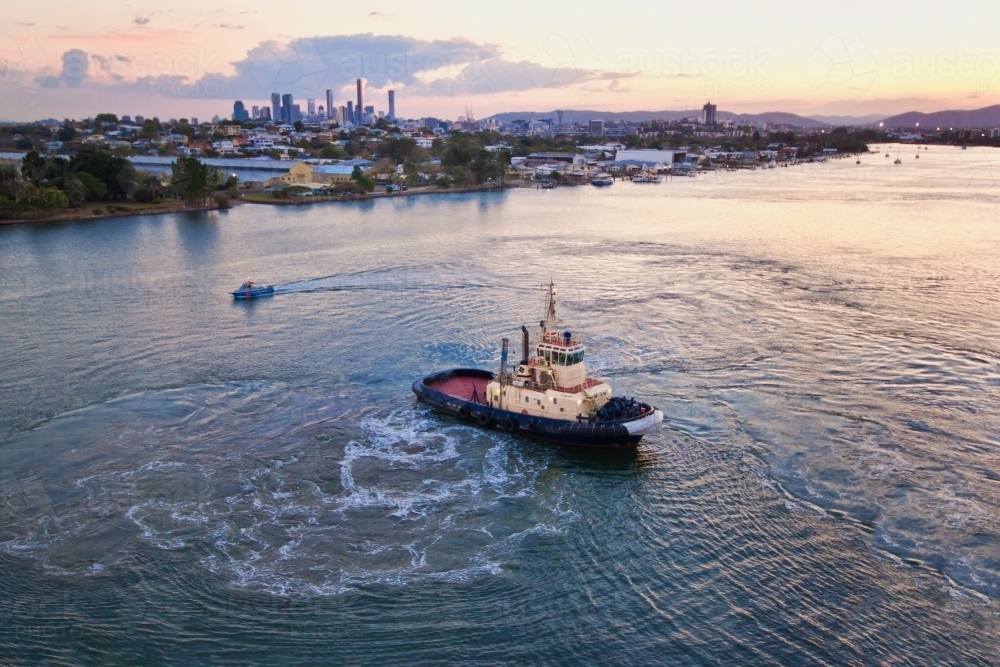 Tugboat ferry at sunrise on the Brisbane River with city views - Australian Stock Image