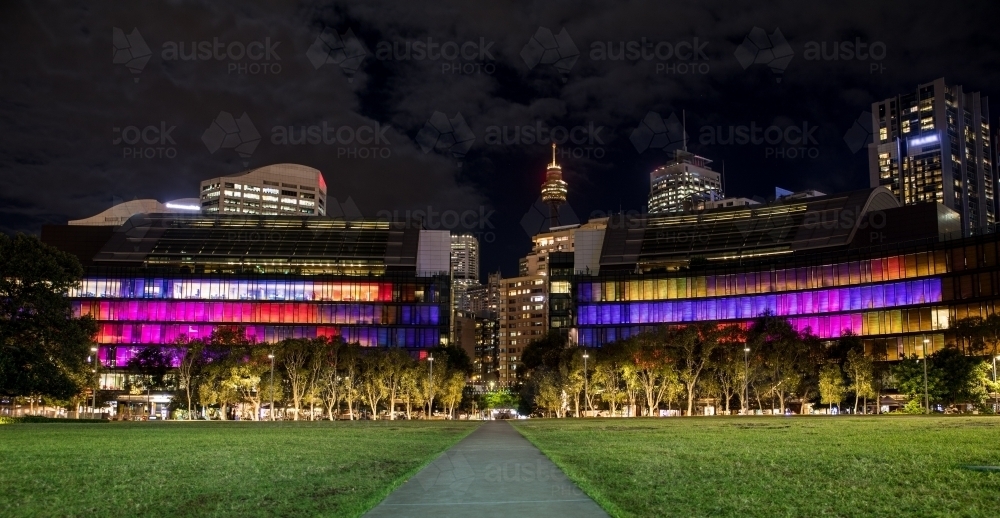 Tumbalong Park during Sydney's Vivid festival with colourful buildings lit up across the skyline - Australian Stock Image