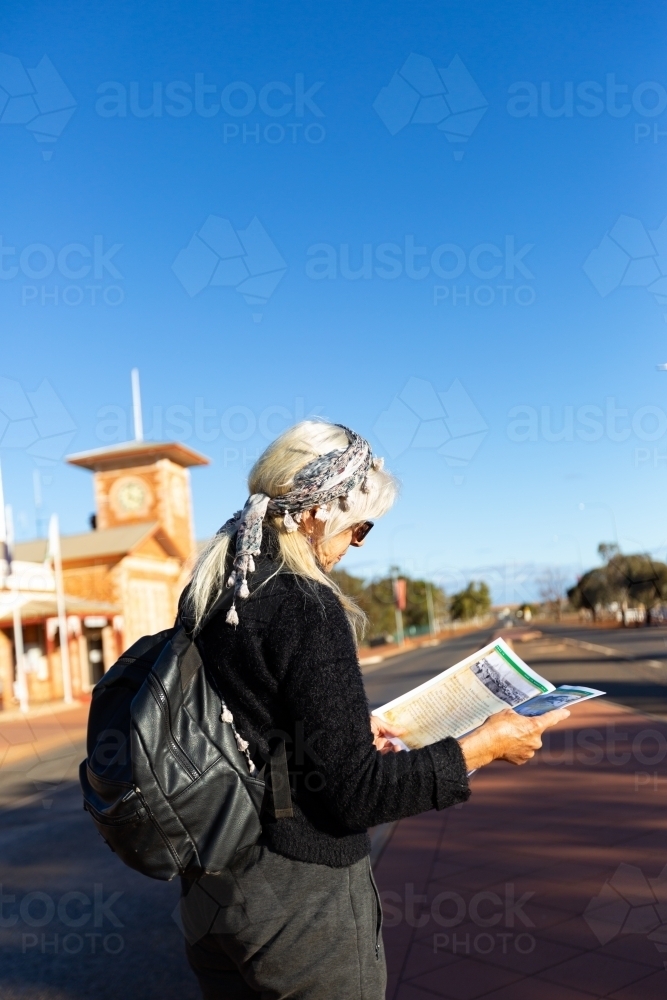 Tourist reading visitors guide in street - Australian Stock Image