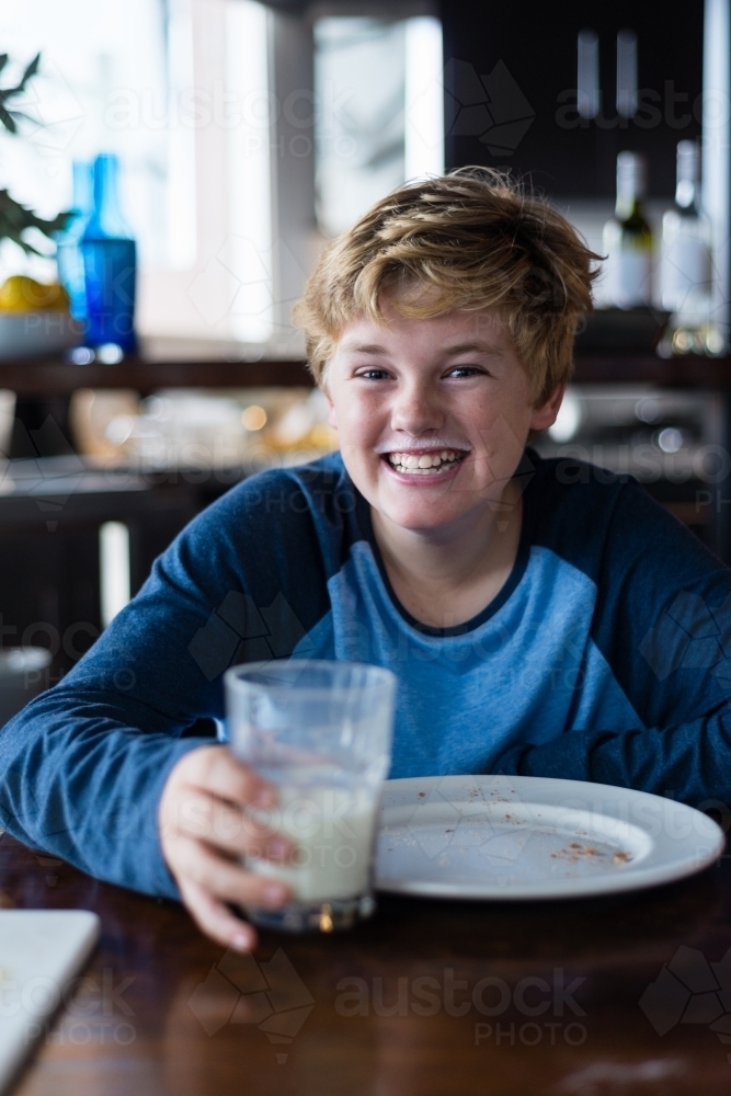 tween boy enjoying toast and milk for breakfast - Australian Stock Image