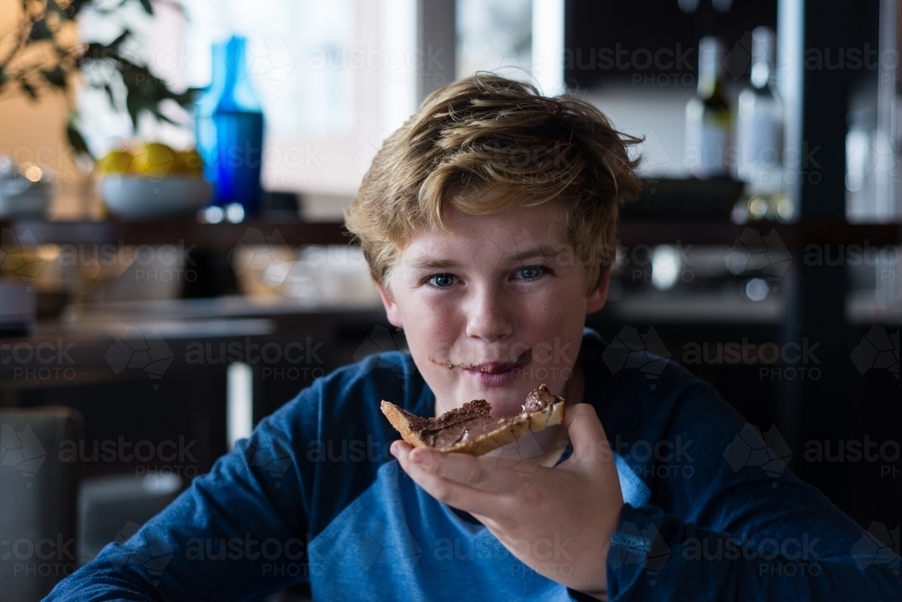 tween boy enjoying toast for breakfast - Australian Stock Image