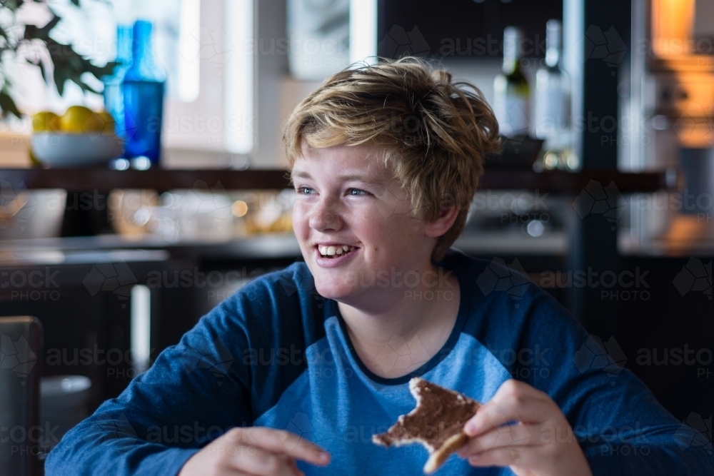 tween boy enjoying toast for breakfast - Australian Stock Image