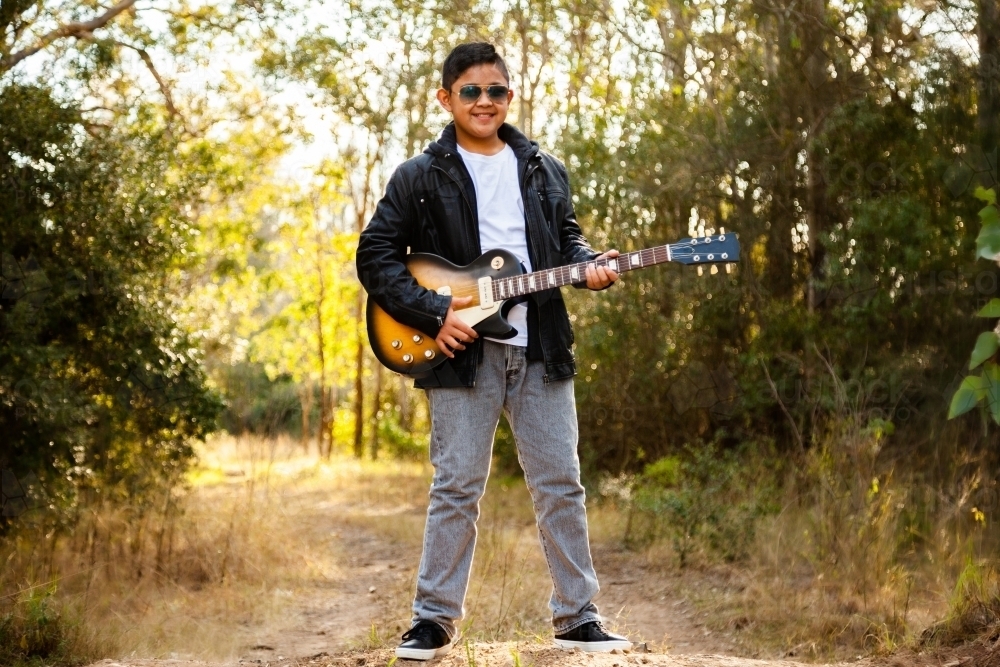 Tween boy looking cool with electric guitar - Australian Stock Image