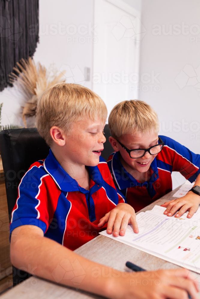 Tween boy working on homework after school at table in living room - Australian Stock Image