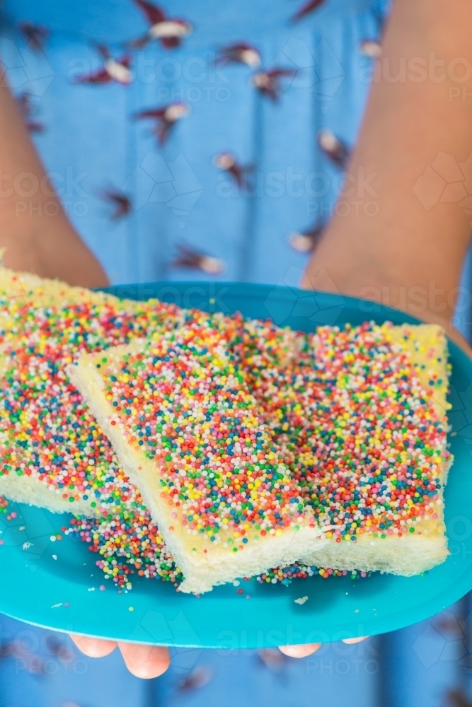 Tween girl holding fairy bread on a plate - Australian Stock Image