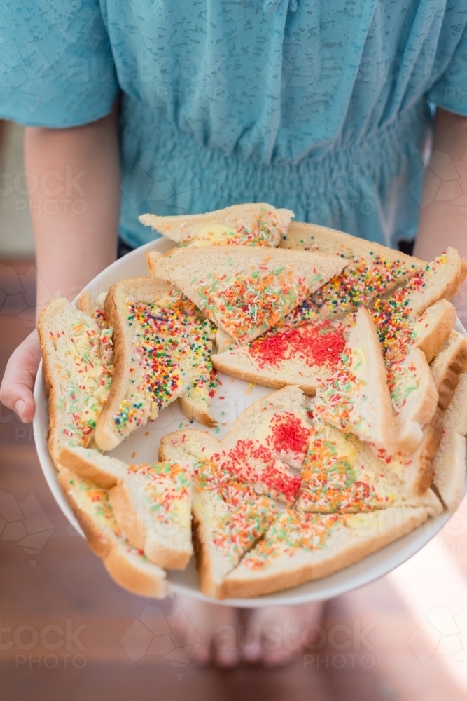 Tween girl holding fairy bread on a plate - Australian Stock Image