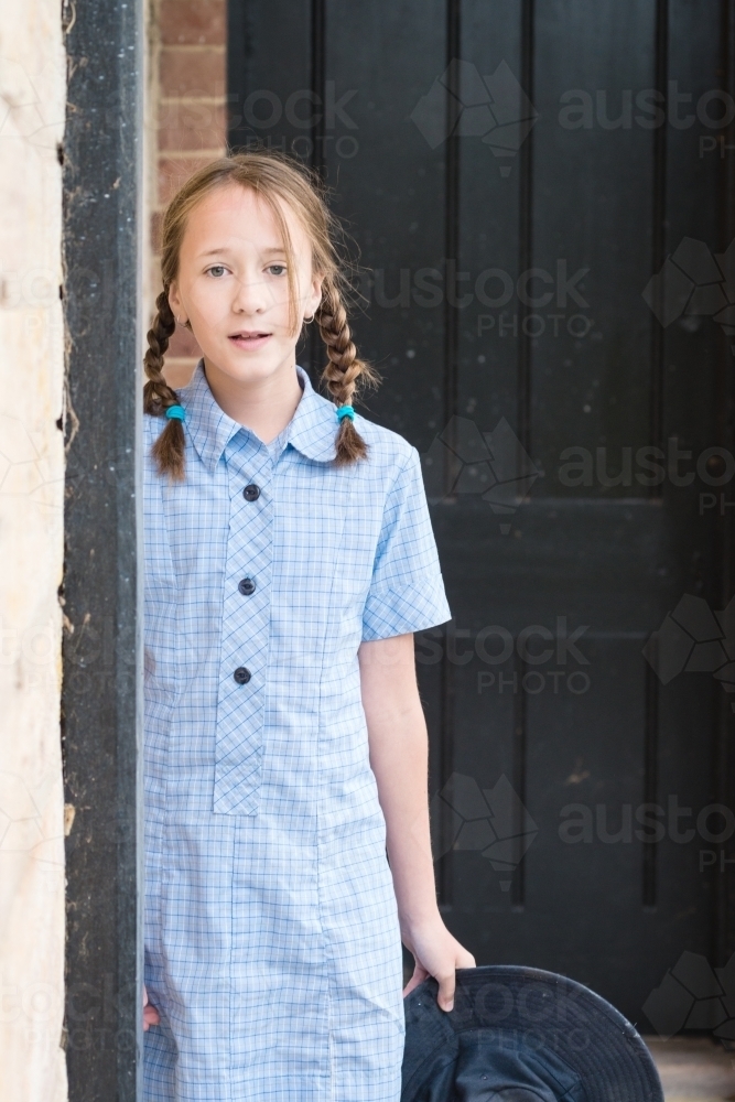 tween girl in blue primary school uniform dress - Australian Stock Image
