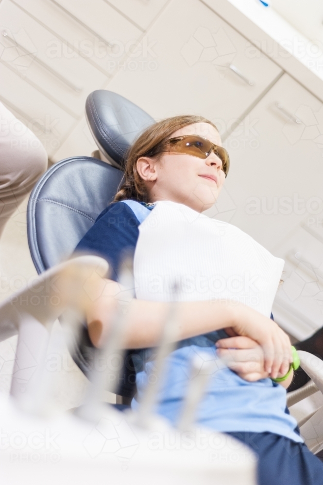 Tween girl lying in a chair at the dentist - Australian Stock Image