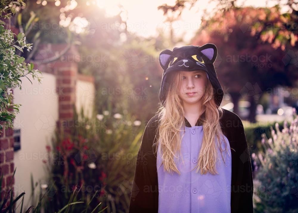 Tween girl with blond hair wearing an animal onesie - Australian Stock Image