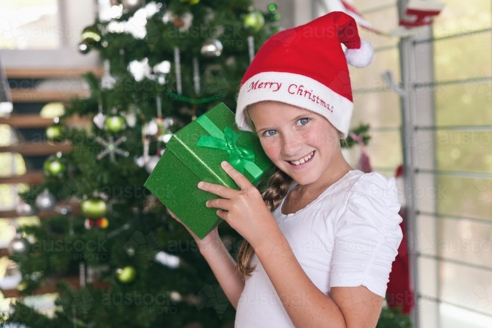tween girl with christmas present on christmas morning - Australian Stock Image