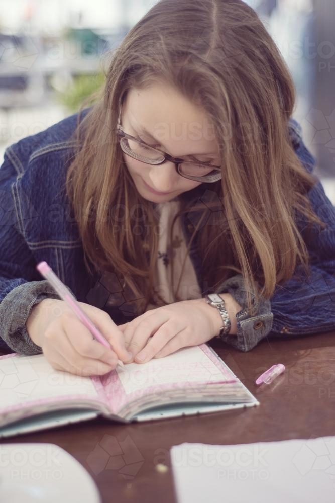 tween girl writing in diary - Australian Stock Image